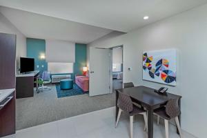 Home2 Suites By Hilton Midland East, Tx في ميدلاند: غرفة مع طاولة طعام وغرفة معيشة