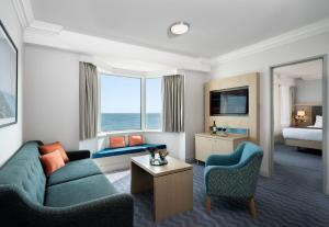 a hotel room with a couch and a bed at Leonardo Royal Hotel Brighton Waterfront in Brighton & Hove