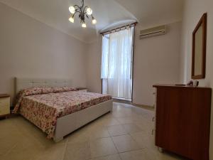 a bedroom with a bed and a large window at Casa Igea in Siracusa
