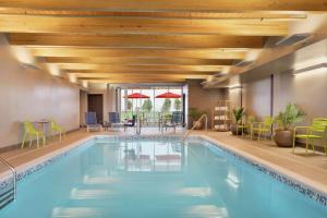 una piscina dell'hotel con sedie, tavoli e ombrelloni di Home2 Suites By Hilton Martinsburg, Wv a Martinsburg