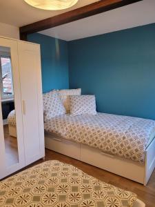 1 dormitorio con cama y pared azul en L'Appart avec terrasse - centre historique, en Barr