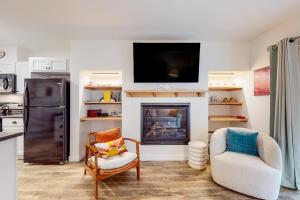 a living room with a fireplace with a tv above it at Mountainside 70 in Warren