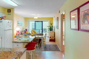 a kitchen and dining room with a table and a refrigerator at Beach Bliss in Ocean Isle Beach