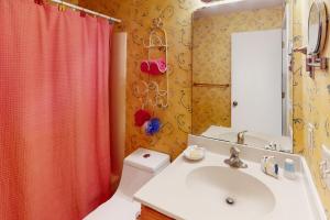 a bathroom with a sink and a red shower curtain at Beach Bliss in Ocean Isle Beach
