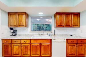 een keuken met houten kasten en een spoelbak bij Bahama Blue Retreat in Bradenton