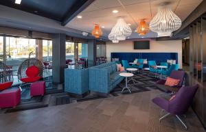 un restaurant avec des tables et des chaises bleues et rouges dans l'établissement Tru By Hilton Phoenix Glendale Westgate, à Glendale