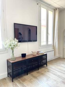 a living room with a television on a wall at Ravissant appartement à 50m port + Parking in La Ciotat