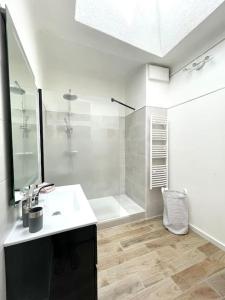 a white bathroom with a sink and a shower at Ravissant appartement à 50m port + Parking in La Ciotat
