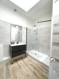 a white bathroom with a sink and a shower at Ravissant appartement à 50m port + Parking in La Ciotat