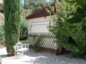 a garage with a white chair next to a tree at HOME Ste Maxime in Le Muy