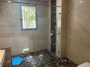 een badkamer met een douche en een raam bij Villa Dada in M'diq