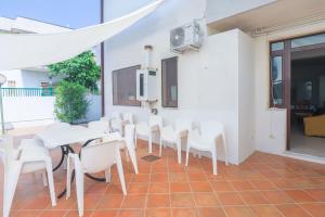 een eetkamer met witte tafels en witte stoelen bij Paolino Housing in Paestum
