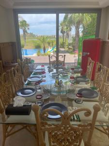 een tafel met stoelen en borden erop bij Villa Dada in M'diq
