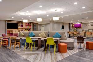 a lobby with tables and chairs and a cafeteria at Home2 Suites by Hilton North Plano Hwy 75 in Plano