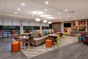 a lobby with a couch and tables and chairs at Home2 Suites by Hilton North Plano Hwy 75 in Plano