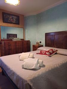 1 dormitorio con 1 cama grande y toallas. en CASA VACANZE CA' MORESCHI, en Berzo