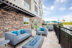 un patio avec des canapés et des chaises dans un bâtiment dans l'établissement Hampton Inn & Suites North Port, Fl, à North Port