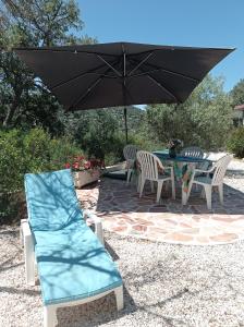 a patio with a table and chairs and an umbrella at HOME Ste Maxime in Le Muy