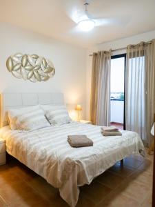 a bedroom with a large white bed and a window at Casa Mimi - your perfect family getaway in Corralejo