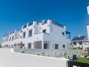 a white building with a fence in front of it at Casa Mimi - your perfect family getaway in Corralejo