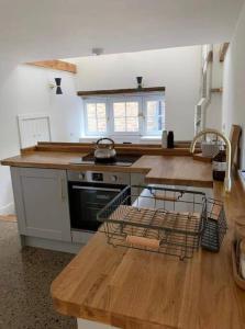 a kitchen with a stove and a counter top at Stunning Barn, Bowes, Barnard Castle in Barnard Castle