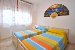 twee bedden in een kamer met een schilderij aan de muur bij Paolino Housing in Paestum