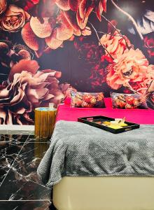 1 dormitorio con 1 cama con pared de flores en Luxury Kim Apartment, Ocean View & Wifi Free, en Playa Paraiso