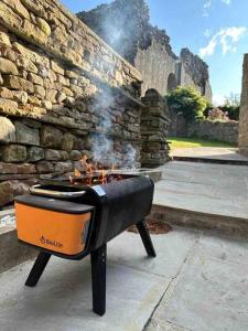 a grill sitting next to a stone wall at Stunning Barn, Bowes, Barnard Castle in Barnard Castle
