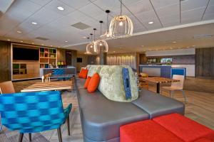 a living room with a couch and some tables and chairs at Home2 Suites By Hilton Bowling Green, Oh in Bowling Green
