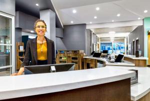 a woman sitting at a counter in an office at Home2 Suites by Hilton Minneapolis Downtown in Minneapolis