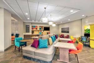 a living room with a couch and tables and chairs at Home2 Suites by Hilton Minneapolis Downtown in Minneapolis