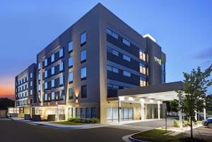 ein großes schwarzes Gebäude mit Parkplatz in der Unterkunft Home2 Suites By Hilton Raleigh North I-540 in Raleigh