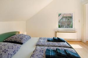 1 dormitorio con 2 camas y ventana en Villa Fokken Steuermannsquartier, en Esens