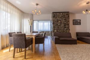 Una sala de estar con mesa de comedor y sillas. en Vila Etiquette, en Predeal