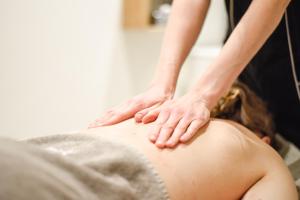 a woman getting a massage from a therapist at Bella Hotel & Restaurant with private dock for mooring boats in San Felice del Benaco