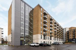 a tall building with cars parked in a parking lot at The Wimbledon Collection in London