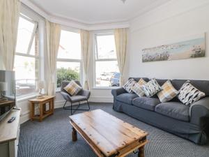 uma sala de estar com um sofá e uma mesa de centro em 5 Stafford Road em Paignton