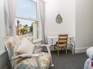 Zimmer mit einem Stuhl, einem Schreibtisch und einem Fenster in der Unterkunft 5 Stafford Road in Paignton