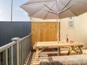a picnic table with an umbrella on a deck at 5 Stafford Road in Paignton