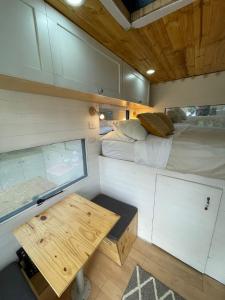 a tiny house with a table and a bed at Yarumo Camper Trailer in Guasca