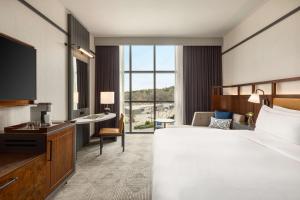 a hotel room with a large bed and a desk at Valley Hotel Homewood Birmingham - Curio Collection By Hilton in Birmingham