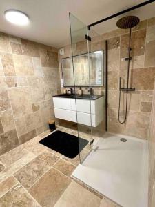 y baño con ducha con lavabo y cabina de ducha acristalada. en Villa Martha - Appt 01, en Guéthary