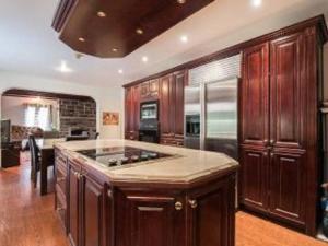 a kitchen with wooden cabinets and a large island at Amazing 8BR Suites Waterview House & SPA in Montréal