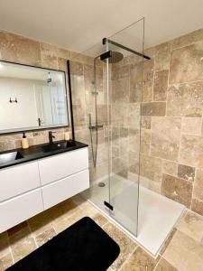 y baño con ducha acristalada y lavamanos. en Villa Martha - Appt 01, en Guéthary
