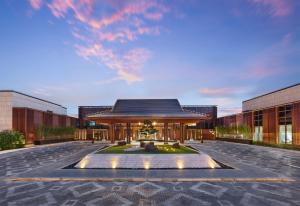 a building with a fountain in the middle of a courtyard at Hilton Shanghai Songjiang Guangfulin in Songjiang