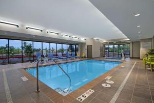 uma piscina num hotel com cadeiras e mesas em Home2 Suites By Hilton Salem em Salem