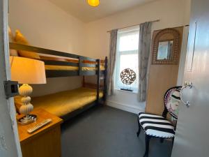 a bedroom with bunk beds and a desk and a window at The Mayfield Boutique Guest House in Blackpool