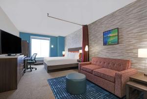 a hotel room with a couch and a bed at Home2 Suites By Hilton Salem in Salem