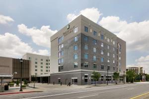 a large building on a city street with a road at Embassy Suites by Hilton Atlanta Midtown in Atlanta