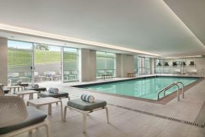 une grande piscine avec des chaises et une table dans l'établissement Embassy Suites by Hilton Atlanta Midtown, à Atlanta